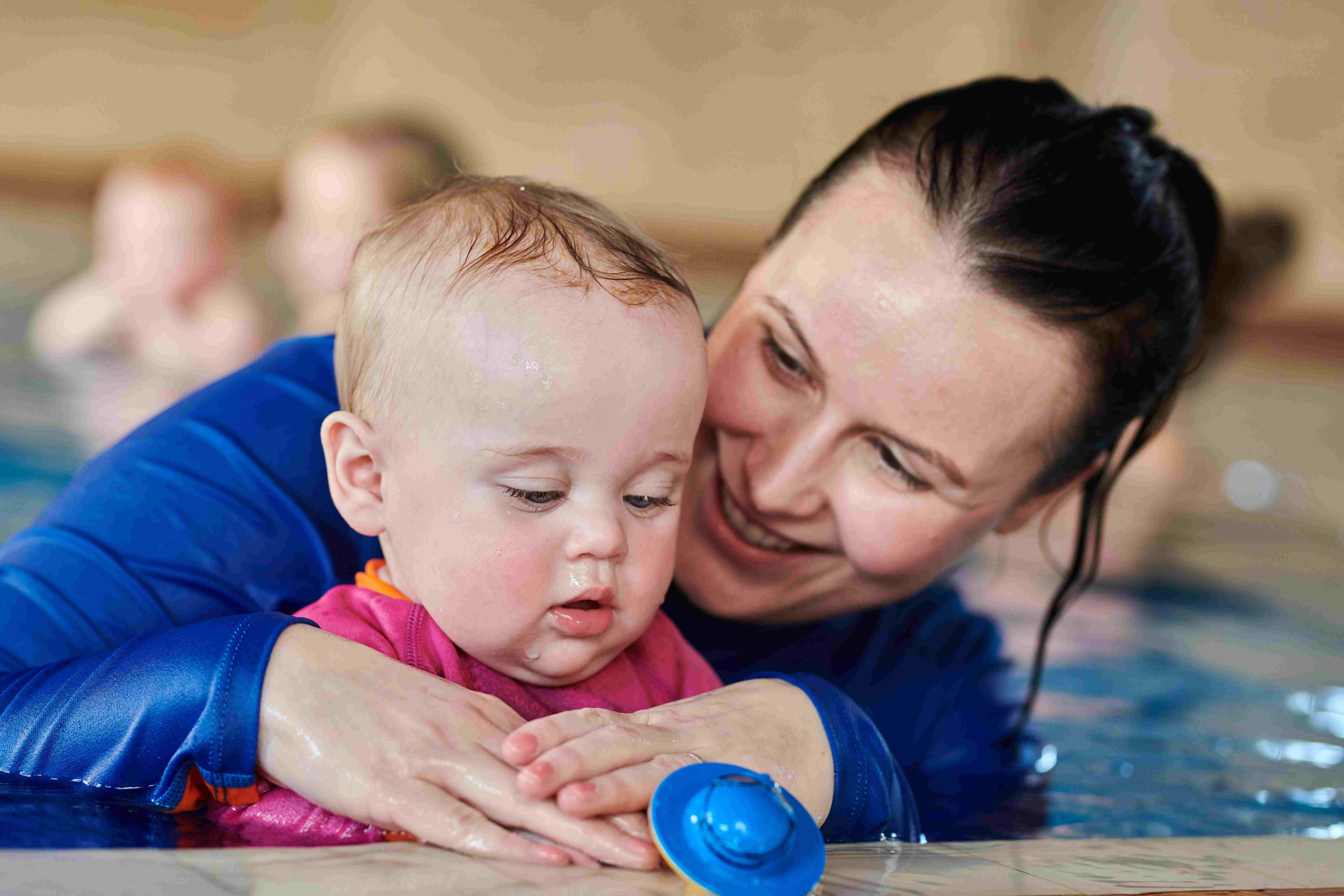 water babies teacher and toddler holding on in lesson