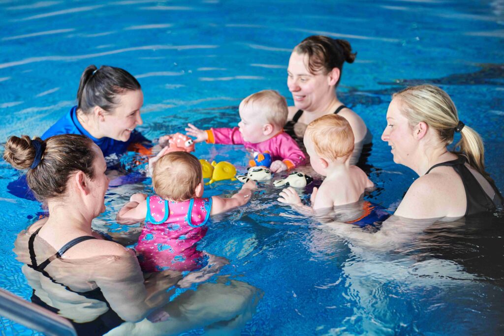 Water Babies winter lesson with moms and babies playing with toy fish.