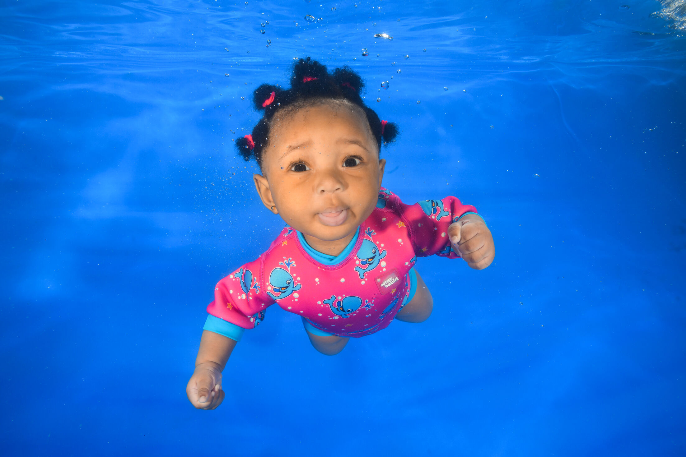 Cute little girl swimming at underwater photoshoot