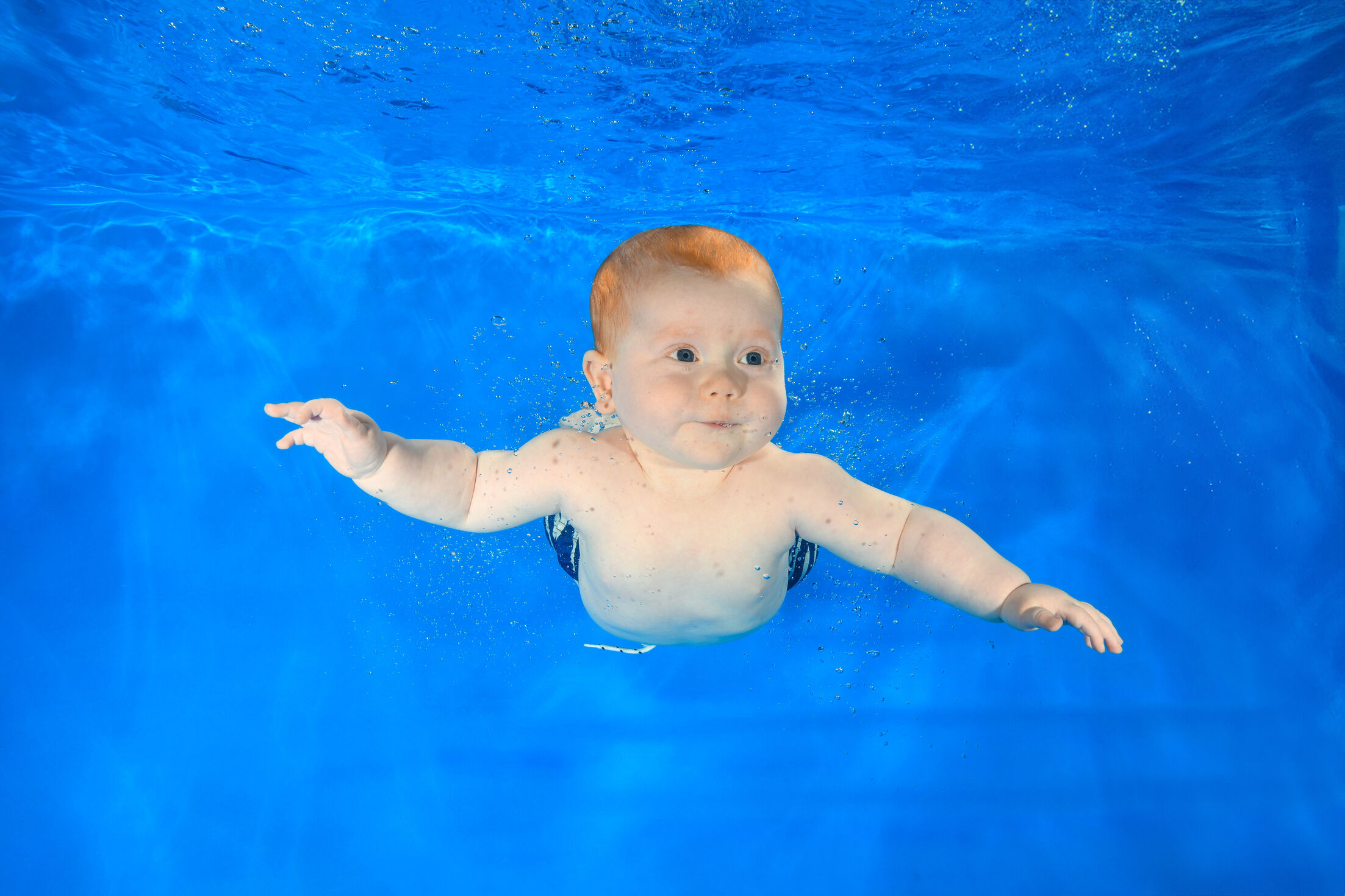 Cute little boy swimming at underwater photoshoot